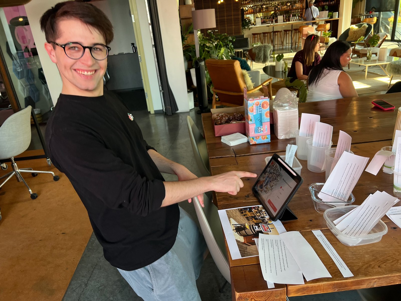 A guest walks through the kiosk prototype, with the paper script cards laid out.